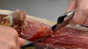 Salumiere che taglia il prosciutto