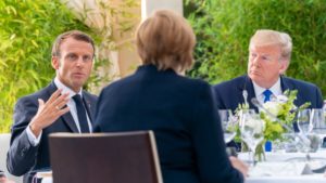Macron con Trump e di spalle Merkel