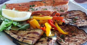 un piatto della dieta mediterranea con pesce e verdure grigliate
