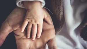 La mano di un bambino sopra quella del padre