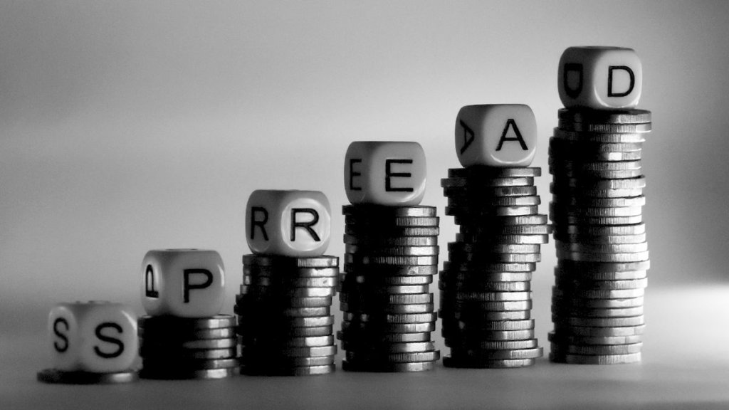 Dadi con la scritta "spread" su pile di monete