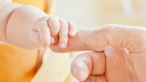 Congedo di paternità: mani di padre e figlio
