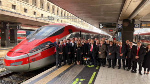 Team Ducati con Bagnaia davanti ad un treno Frecciarossa