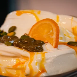 Melody gusto dell’anno di Gelato 2026: base cremosa completata da variegatura di pistacchio, granella di pistacchio e una delicata salsa all’arancia celebrata in tutta Europa