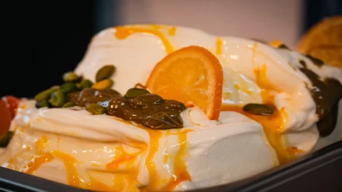 Melody Gelato Flavor of the Year 2026: dasar krim yang dilengkapi dengan pusaran pistachio, pistachio cincang, dan saus jeruk lembut yang terkenal di seluruh Eropa.