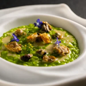 Ein faszinierender und raffinierter Dialog zwischen Land und Meer in dem mit einem Stern ausgezeichneten Rezept aus Reis, wildem Fenchel, Zitrone und Schalentieren von Küchenchef Alfio Nicolosi